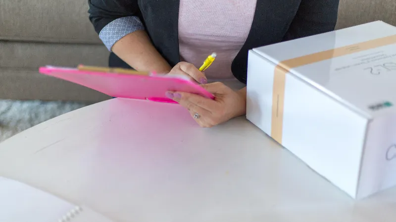 A hand filling out a checklist on a clipboard