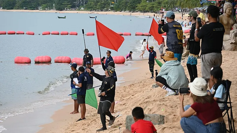 Lifeguards holding red warning flags along a shoreline