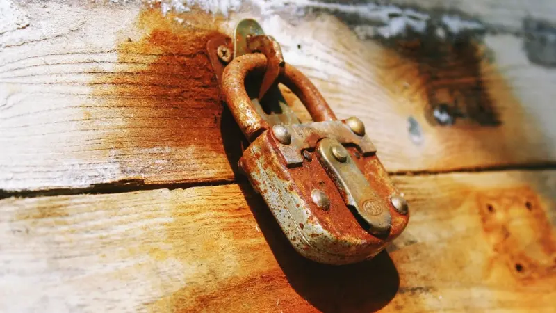 rusty padlock on a weathered wooden door