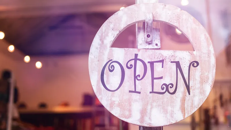 An open sign hanging in a shop window