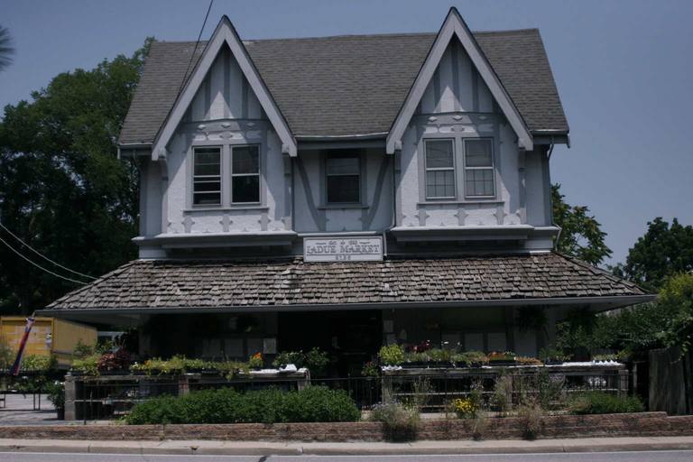 The Ladue Market storefront, a 1928 Tudor building with plants and flowers along its front rail.